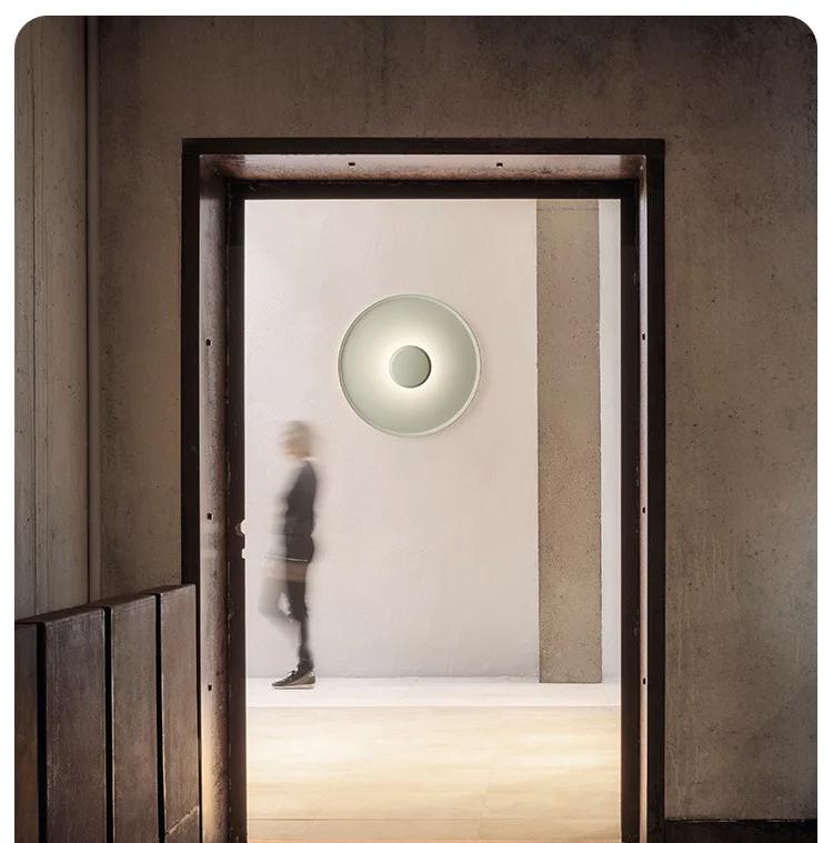 Xelion sage green wall light in an editorial hallway