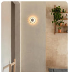 Xelion white wall light beside a plant shelf
