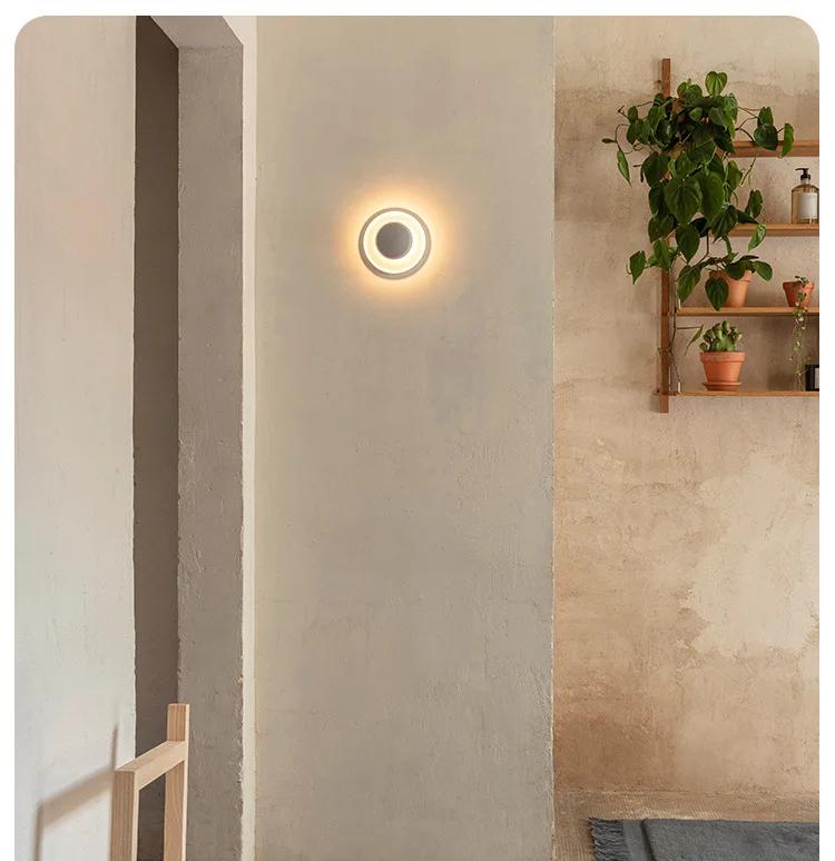 Xelion white wall light beside a plant shelf