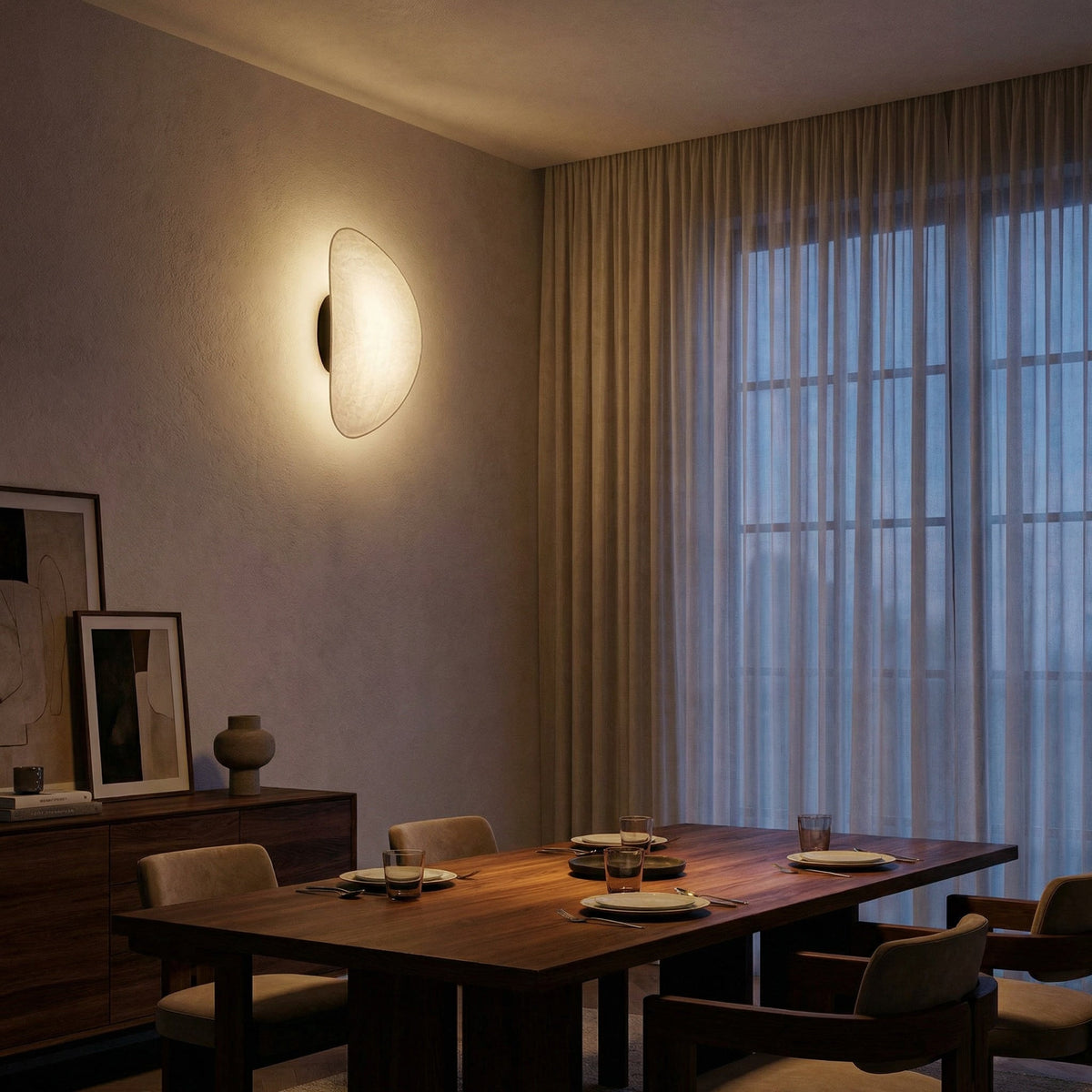 Tenzora organic textured wall sconce lifestyle view over a dining table, warm white light