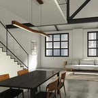Yalvix wave-form linear pendant, 120 cm, over a dining table in an industrial loft