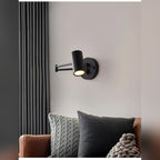 Arqventa matte black swing-arm wall sconce above a bedside table, warm light on