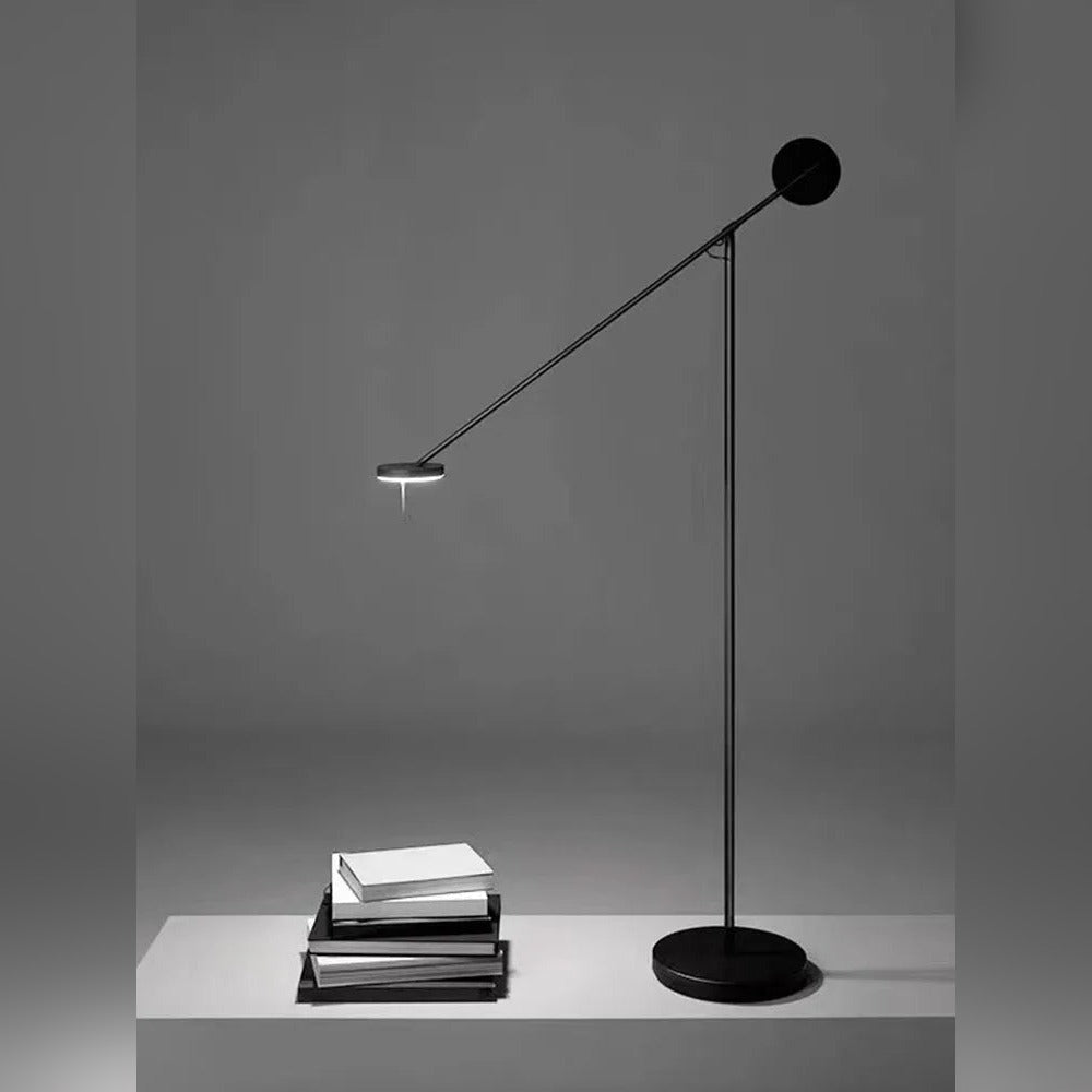 Bilancio floor lamp reading light angled over a stack of books