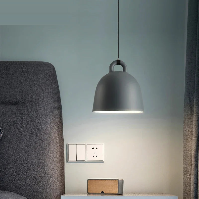 Relavorn resin bell pendant light — Dark Gray finish beside a bed
