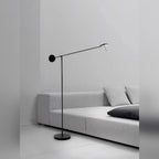 Bilancio floor lamp beside a sofa, arm angled toward the seating
