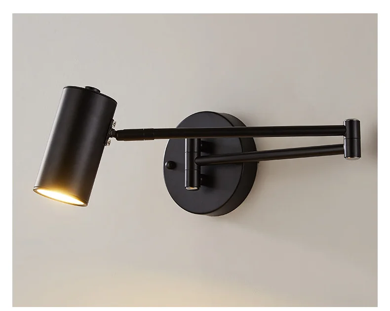 Arqventa matte black swing-arm wall sconce, studio shot, warm light on