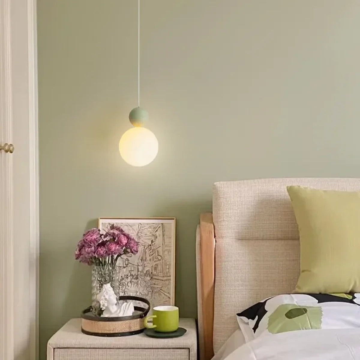 Luniva pendant light in Green colourway beside a nightstand