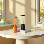 Threshon table lamps in Terracotta Orange and Matte Black on a round table in daylight