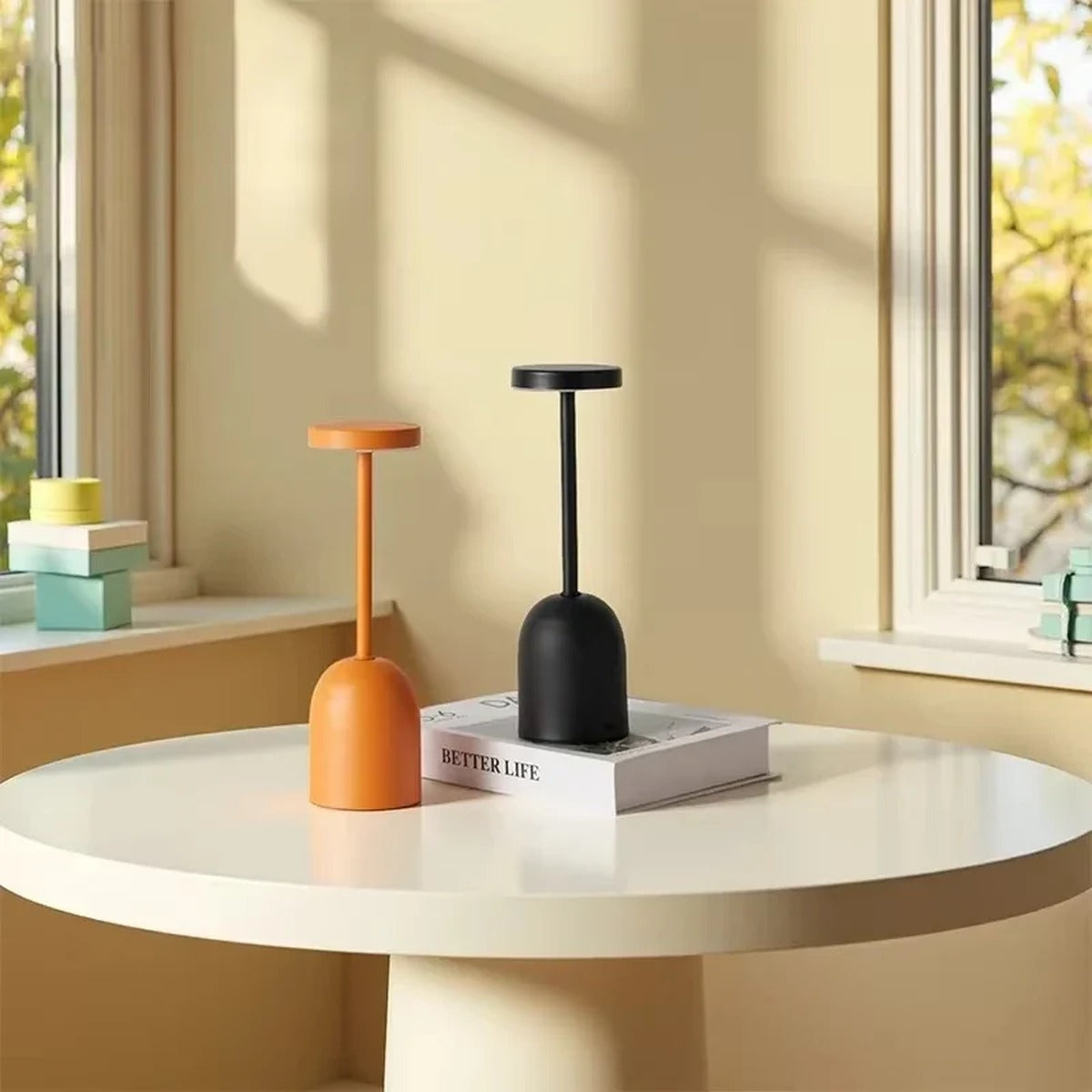 Threshon table lamps in Terracotta Orange and Matte Black on a round table in daylight