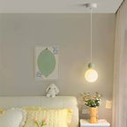 Luniva mini pendant light hanging beside a bed — White