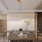 Two Quarren travertine pendants in different lengths over a dining table