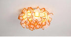 Lumero chandelier, orange-edge acrylic petals, illuminated