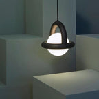 Orbivex matte arc ring pendant — black arc with opal globe in sculpted architectural space