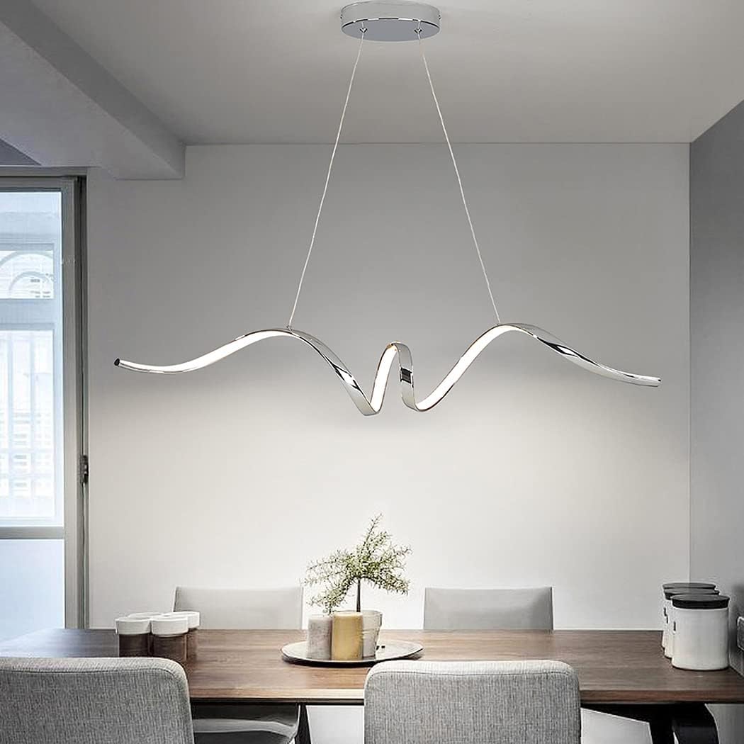 Sculptural aluminium wave pendant light in polished silver finish over a dining table