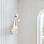 Serengeti giraffe wall sconce, white finish, lit in a hallway — lifestyle