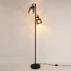 Pivotis floor lamp with two brass-hinged mesh shade heads, both illuminated