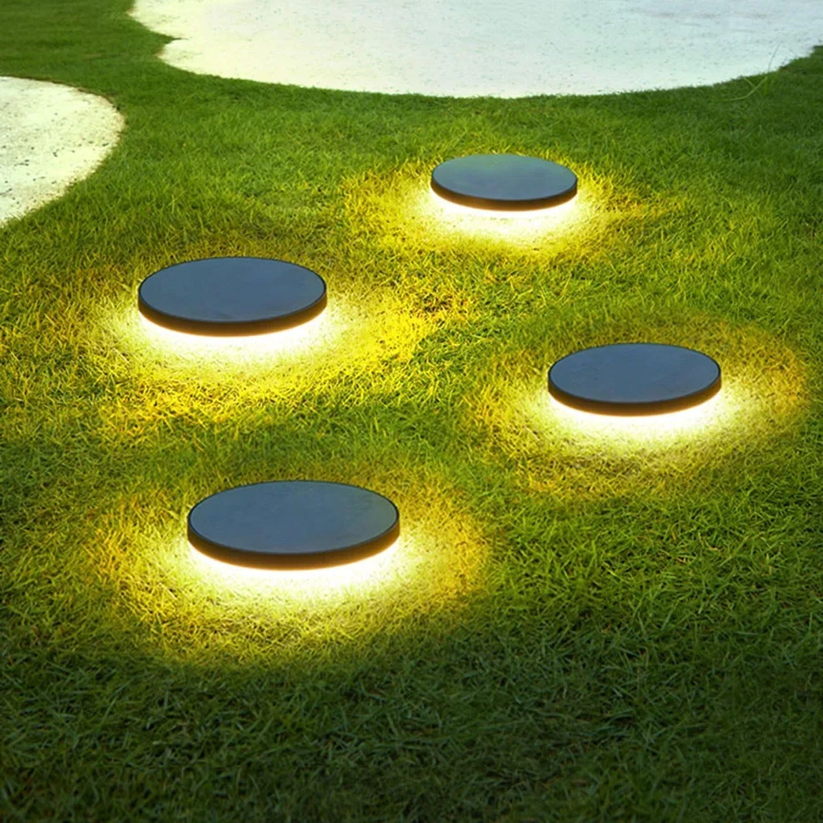 Gathrix bronze dome ground lights illuminating a garden lawn pathway
