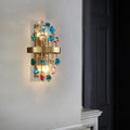 Morvena crystal cluster wall sconce in Rainbow Gemstone Crystal, brushed brass frame, lit in a hallway