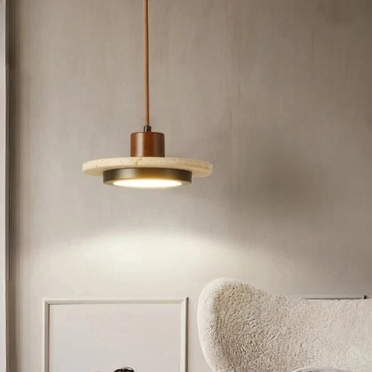 Terravox Travertine Pendant Light — lifestyle view over reading chair