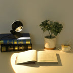 Sculptural Orb Table Lamp Ornaxis — black finish, ambient light on books