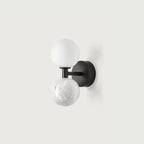 Genival — close-up of marble sphere texture and brass bracket arm