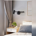 Arqventa matte black swing-arm wall sconce in a bedroom, warm light on