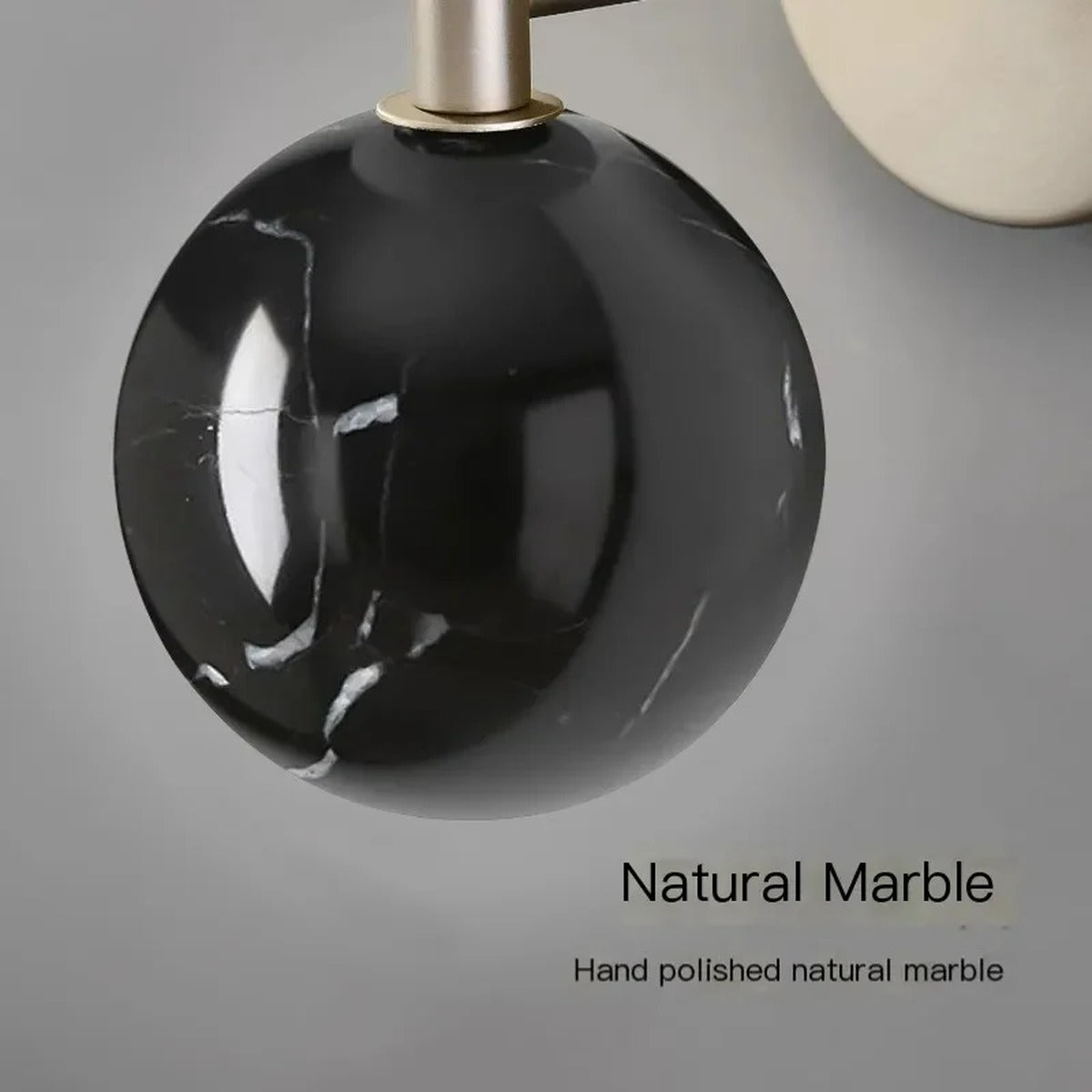 Genival — lit view showing opal glass globe warm glow over marble counterweight