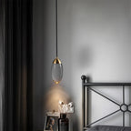 Ovaline pendant light detail, brushed brass cap and glass shade