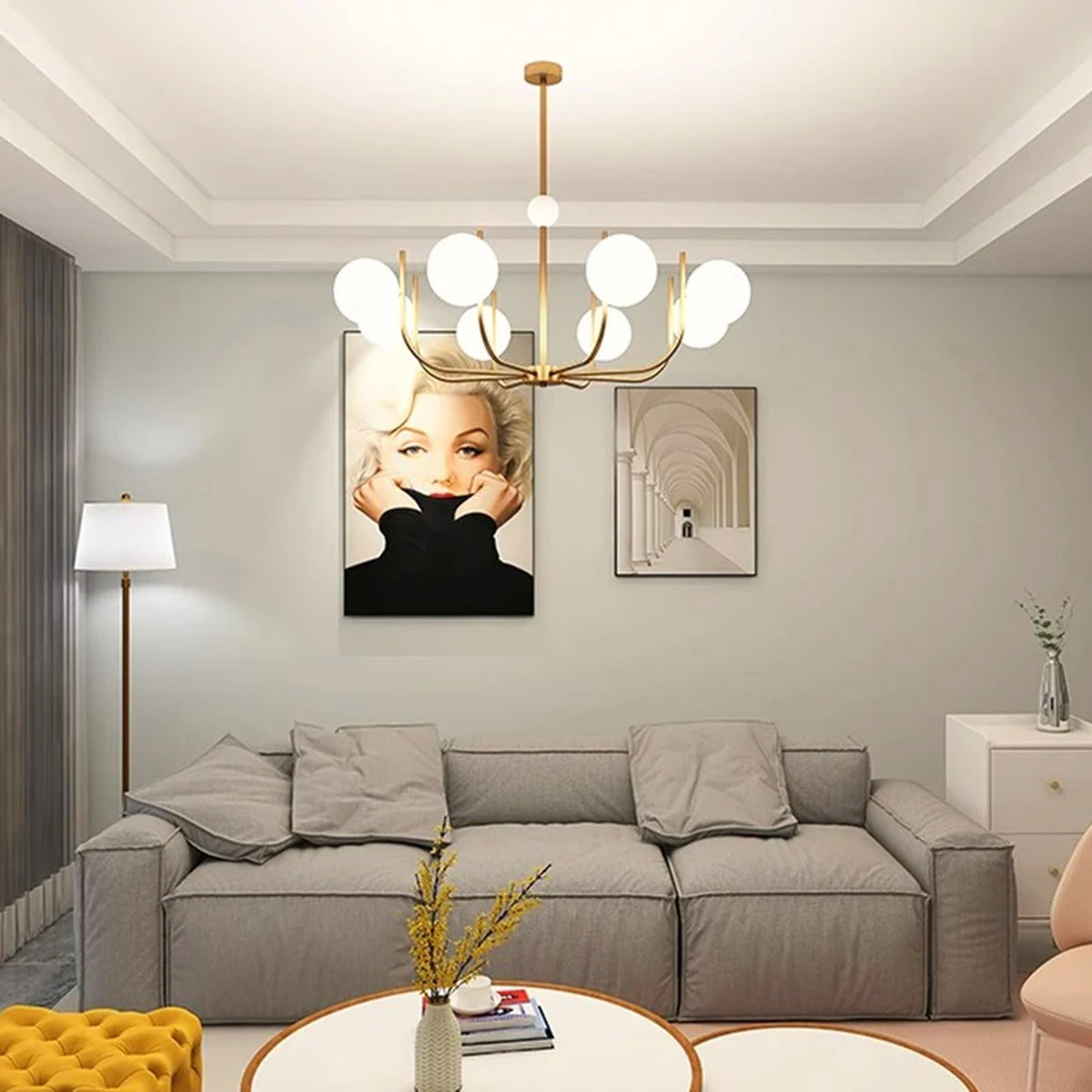 Noctivox chandelier in brushed gold above a living room sofa