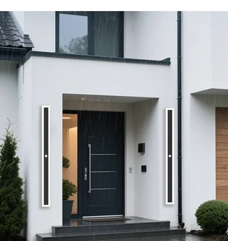 Veltora linear aluminum outdoor wall light installed either side of a front door in the rain