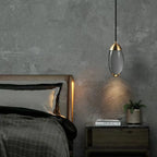 Ovaline pendant light beside a bed, warm glow