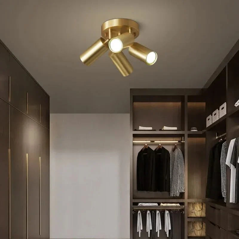 Brushed Gold Pivoting Spotlight Ceiling Light Dirvex – 4-Arm above a bedroom seating area