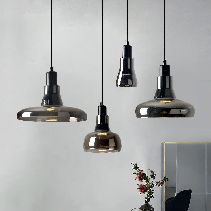 Ozaelix smoked glass pendants – all 4 shapes hanging in interior with grey wall