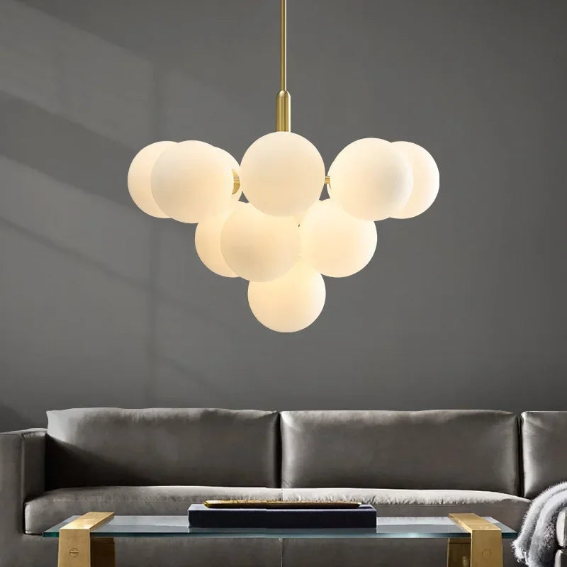 Gornox brass globe cluster chandelier above a living room sofa