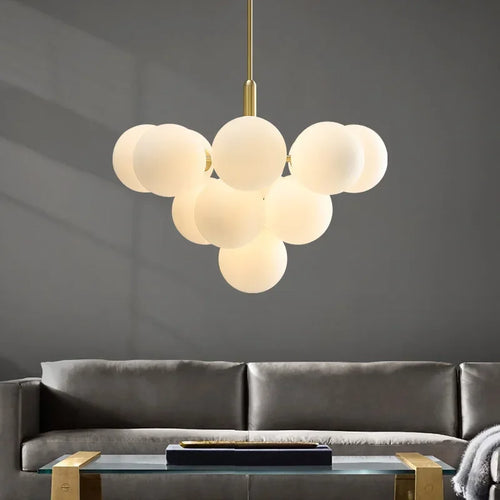 Gornox brass globe cluster chandelier above a living room sofa