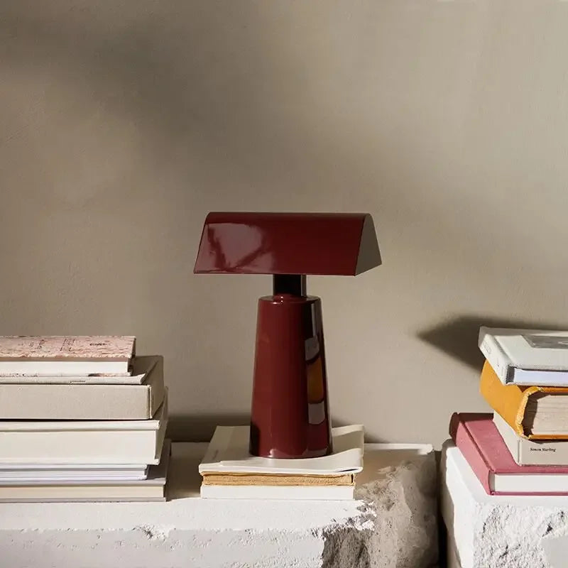 Lacquered Steel Prism Table Lamp Hovelix – Burgundy, lifestyle on stone shelf