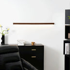 Solvela walnut linear LED wall sconce lit above office cabinet