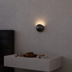 Brivex directional wall sconce, Gloss Black finish, above a bedside table