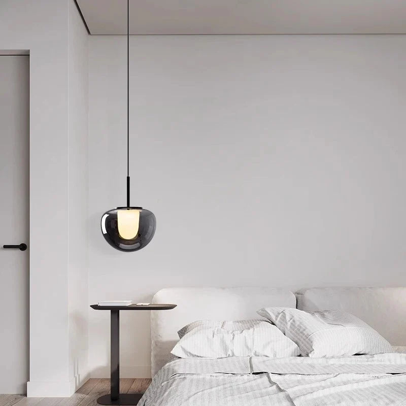 Mzaelvix glass globe pendant – smoke grey in bedroom interior above side table with book