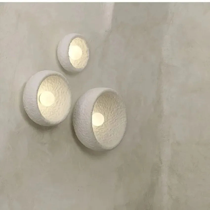 Kalvora plaster wall sconces lit on textured wall