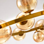 Zwaeron ring chandelier — close-up of amber glass globes and brass frame