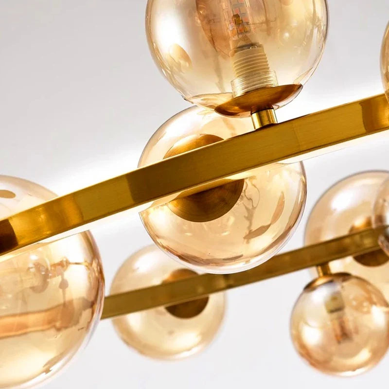 Zwaeron ring chandelier — close-up of amber glass globes and brass frame