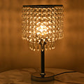 Chrome Crystal-Drop Table Lamp Cavelox lit on a bedside table