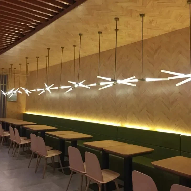 Rarlix multi-arm LED tube chandelier — brushed gold finish over restaurant dining tables
