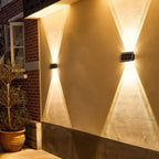 Two Nexford solar wall lights on a brick facade at dusk