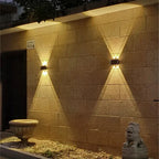 Nexford solar wall light beside a cabin doorway at night