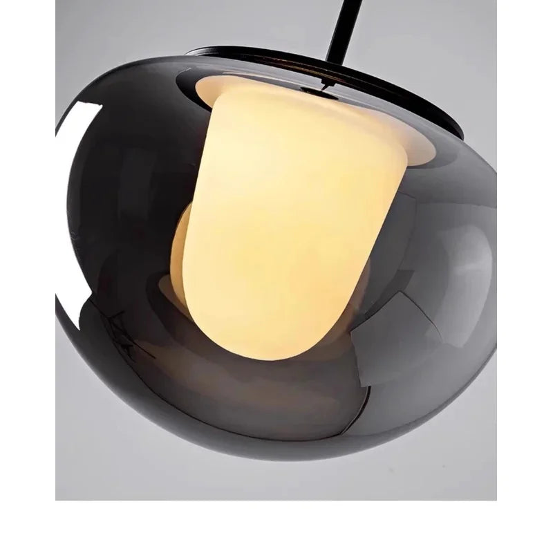 Mzaelvix glass globe pendant – close-up from below, smoke grey glass lit warm white 3000K