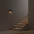 Brivex directional wall sconce, Gloss Black finish, mounted on a staircase wall
