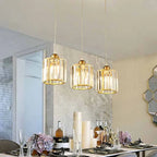 Nzaelion crystal cylinder pendants – 3 gold pendants above dining table with wine bottles and flowers