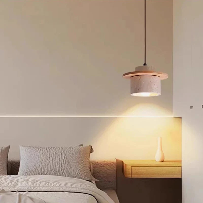 Yellow Travertine drum pendant light with walnut wood trim above a bedside table, warm ambient glow